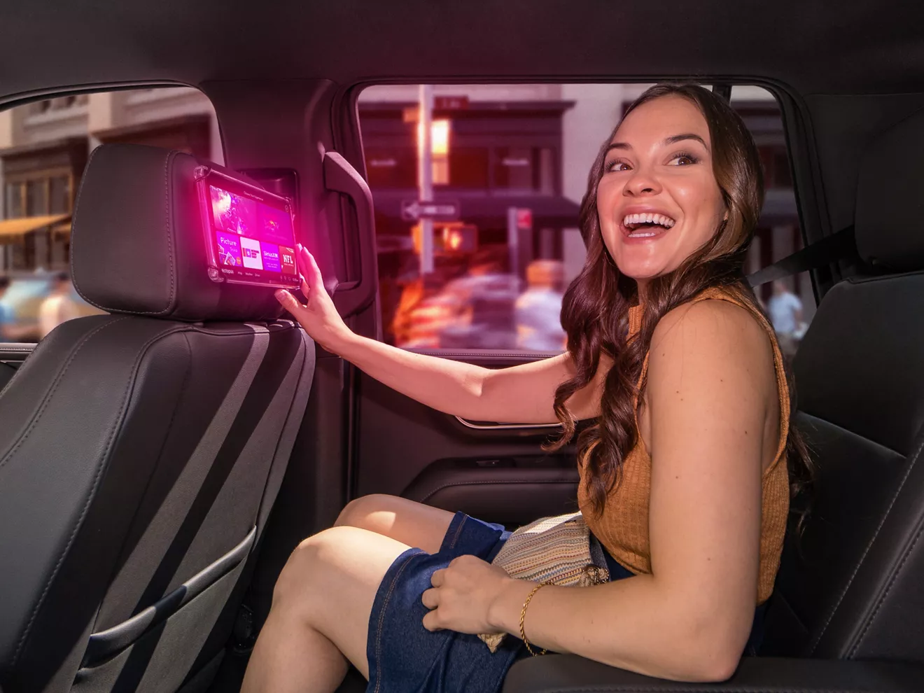 Pasajera sonriendo mientras interactúa con la pantalla táctil publicitaria del vehículo