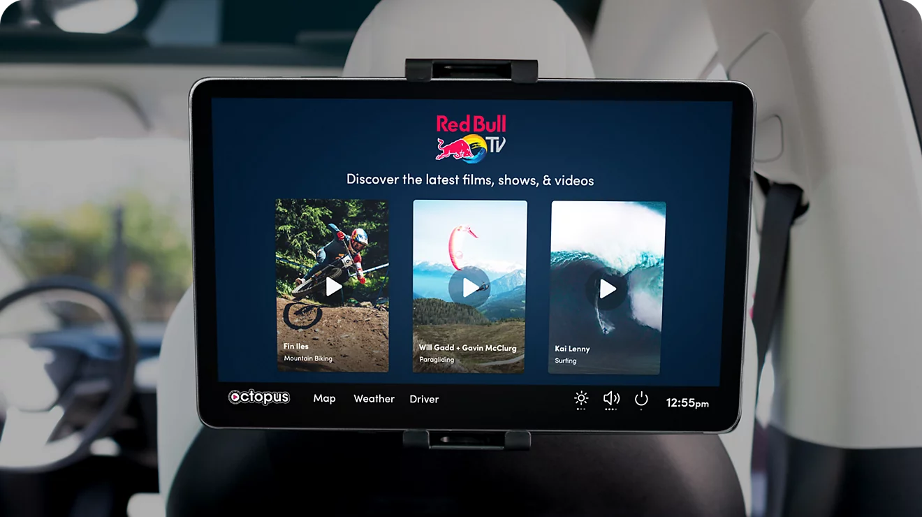 Pantalla táctil montada en el respaldo del asiento de un vehículo reproduciendo contenido publicitario